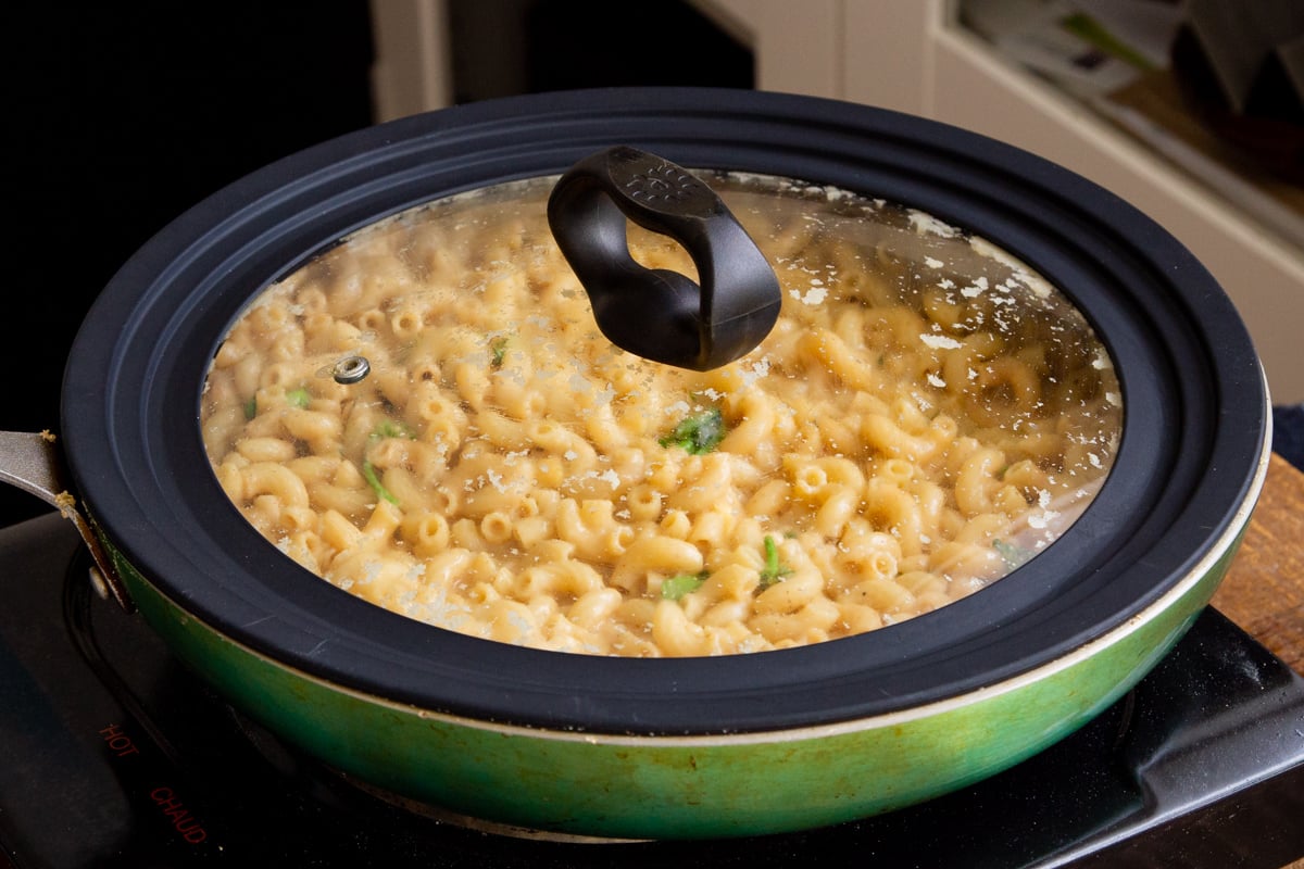 jalapeno mac and cheese simmering in a green skillet with the lid on
