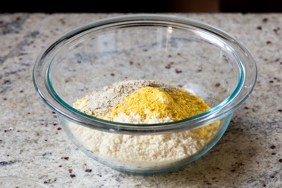 dry ingredients for making vegan cheese balls in a glass bowl