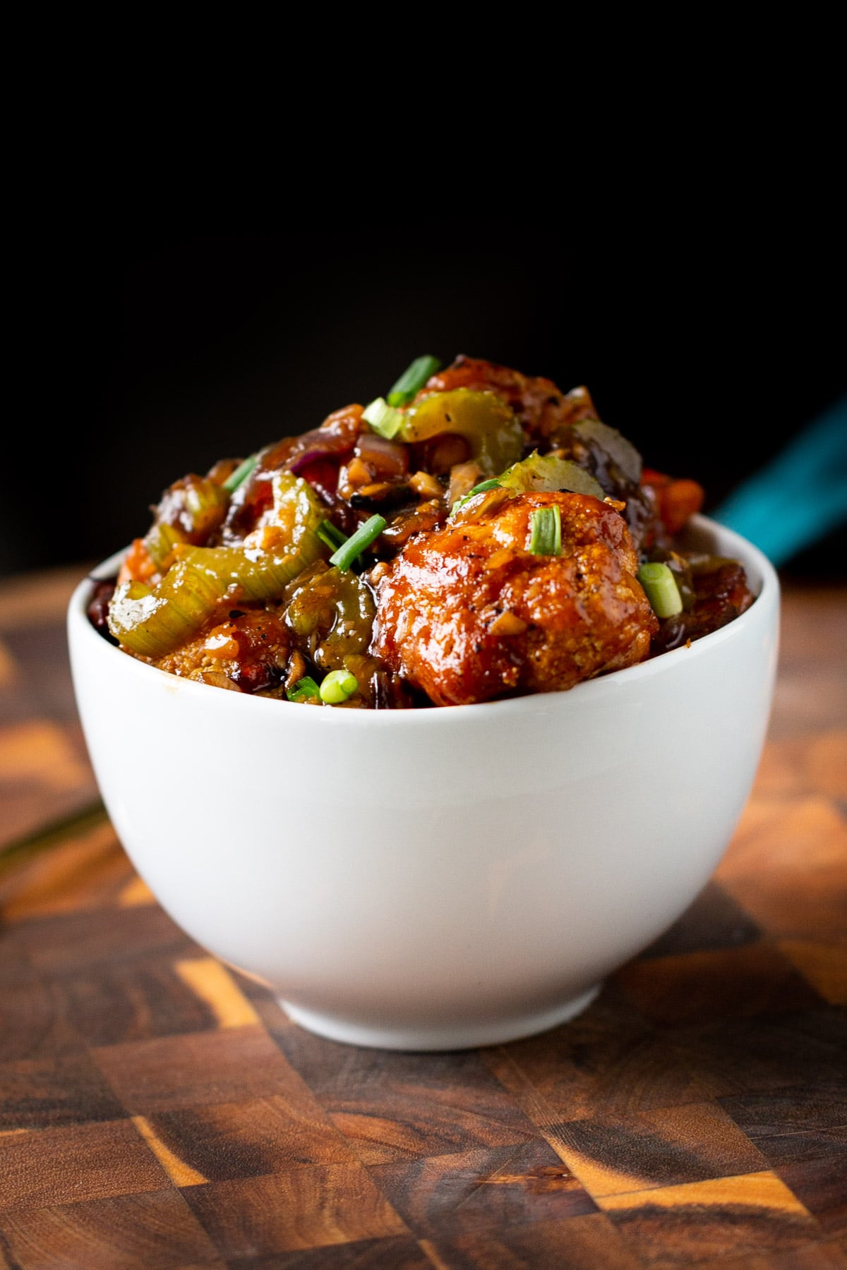 a bowl of vegan black pepper cauliflower coated in sweet spicy sauce