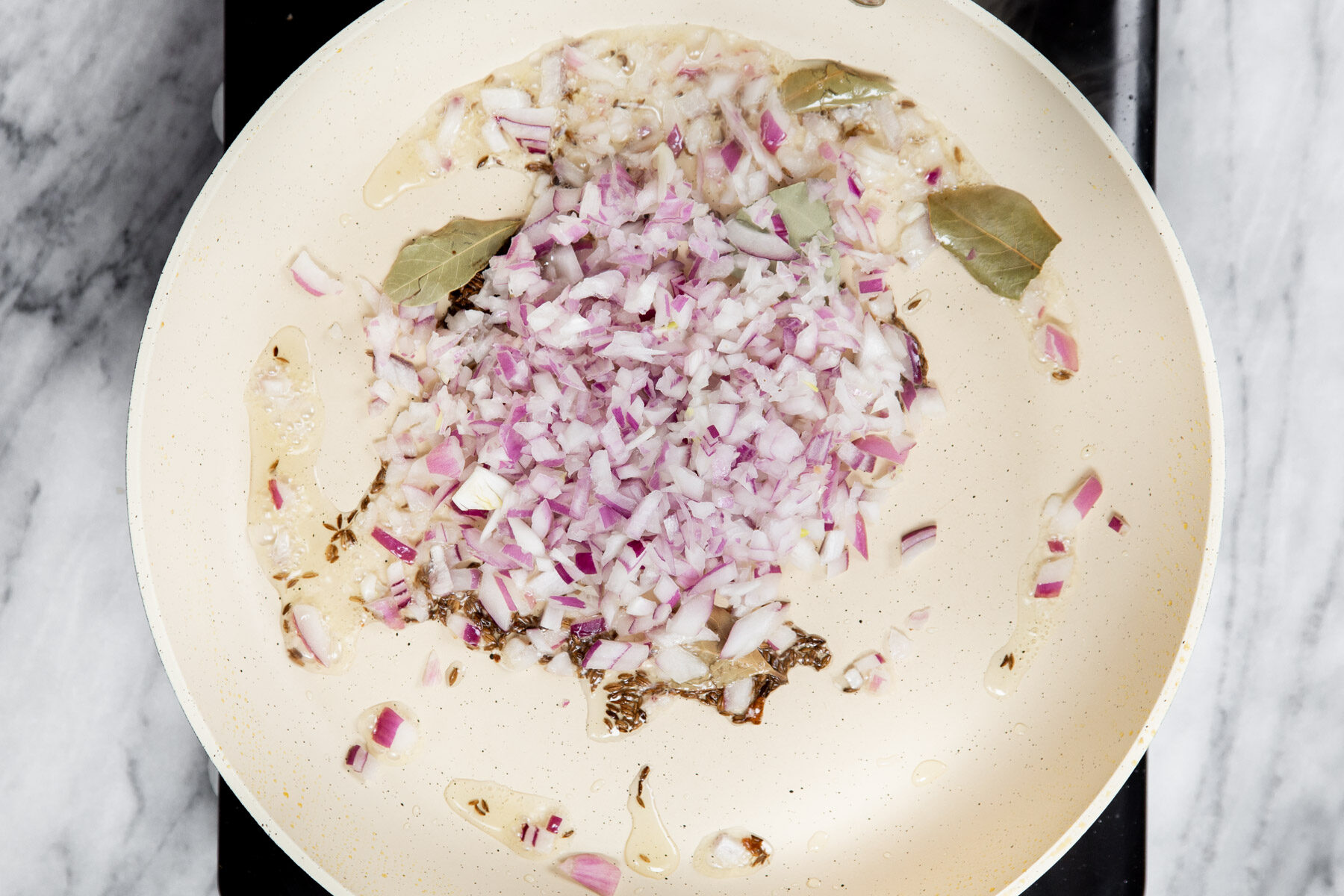onion and spices sauteeing in a pan with oil