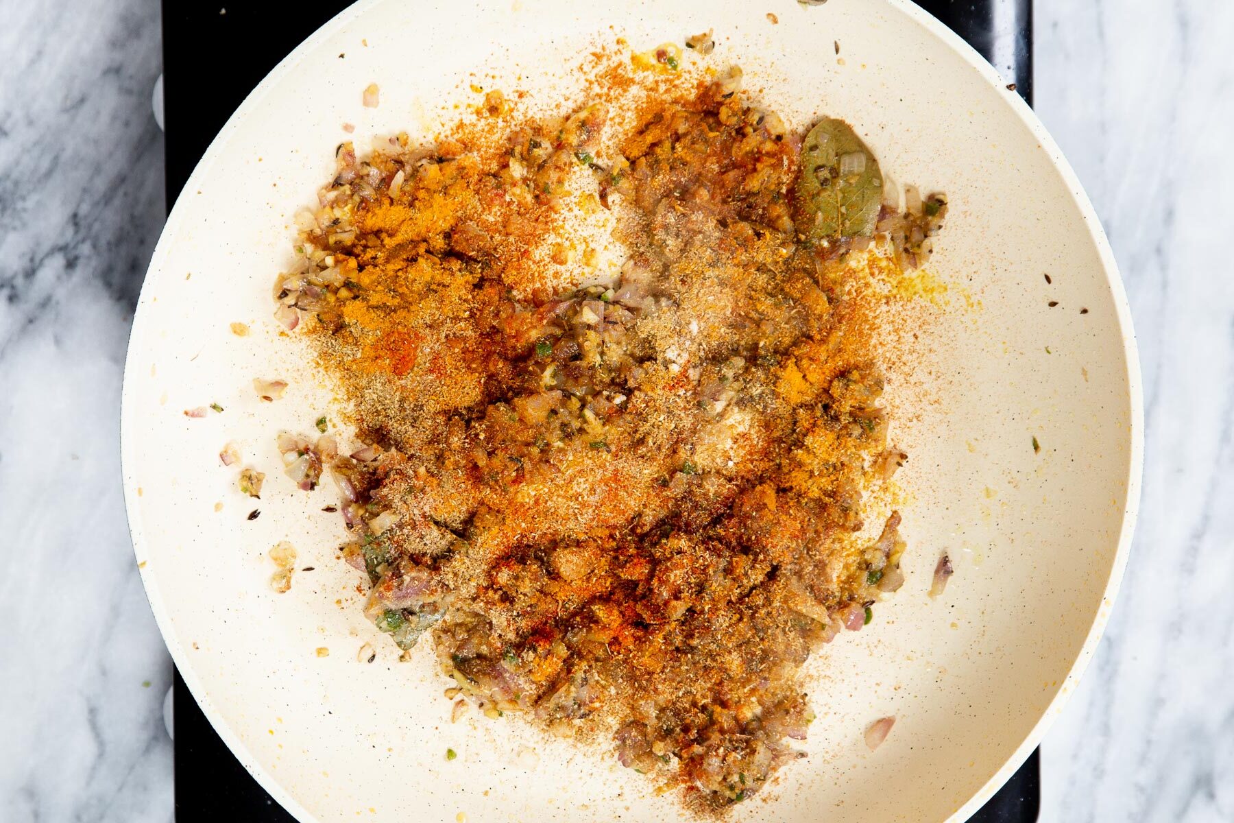 dried ground spices in a sauteeing pan