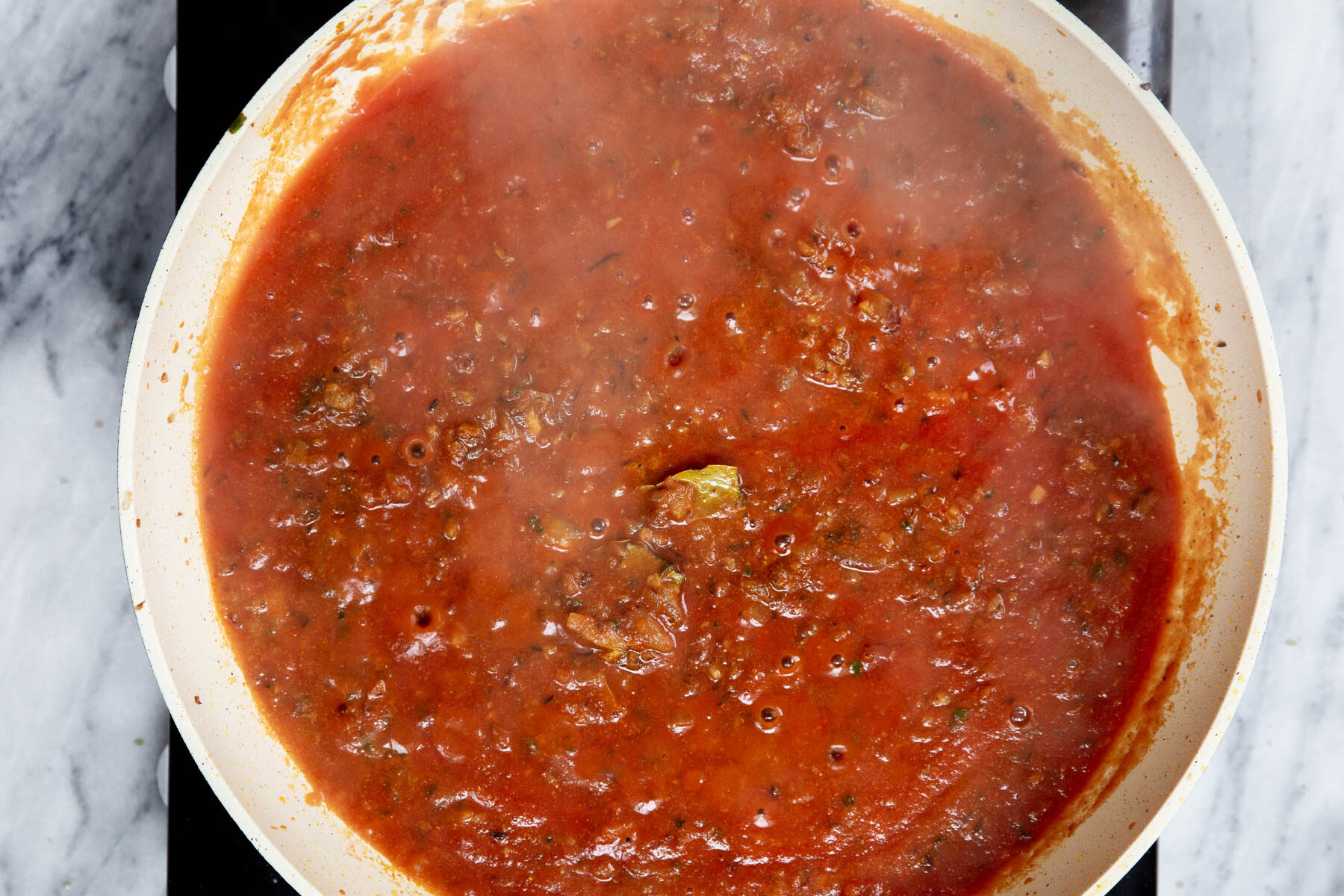 spiced tomato sauce simmering in a pan