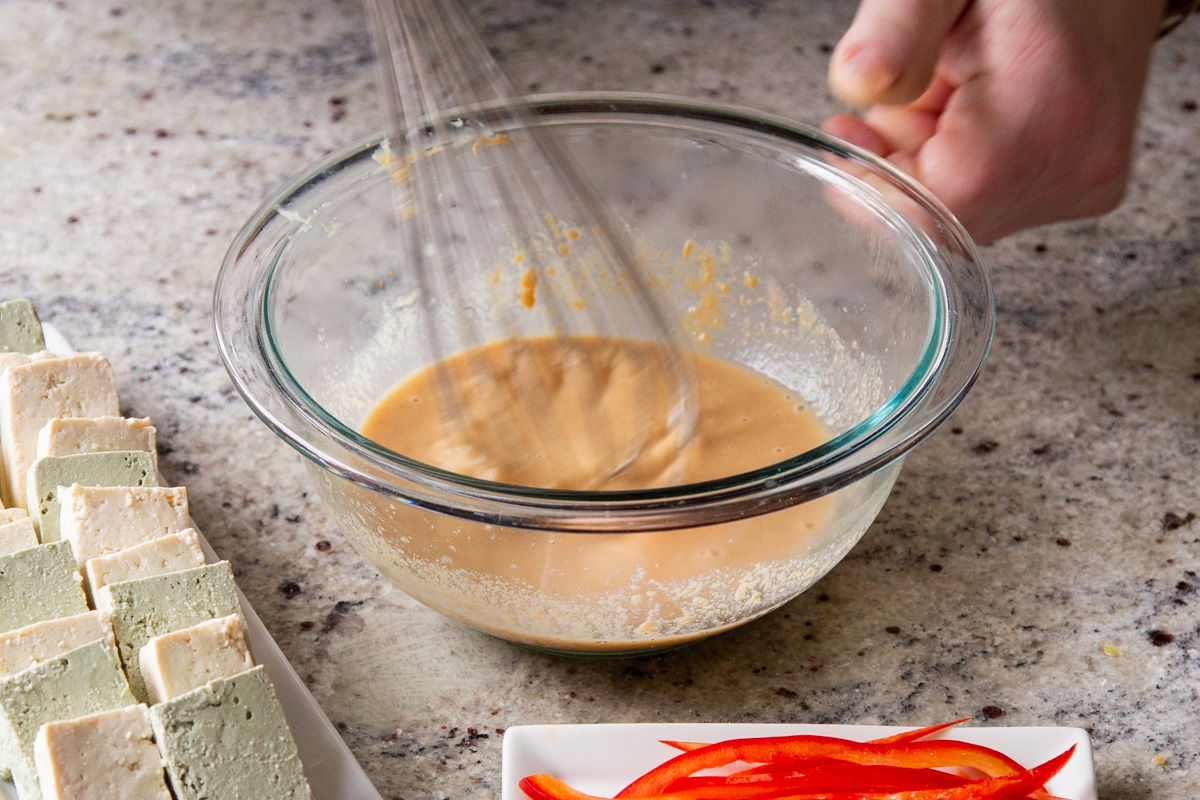 peanut coating for tofu being mixed in a bowl