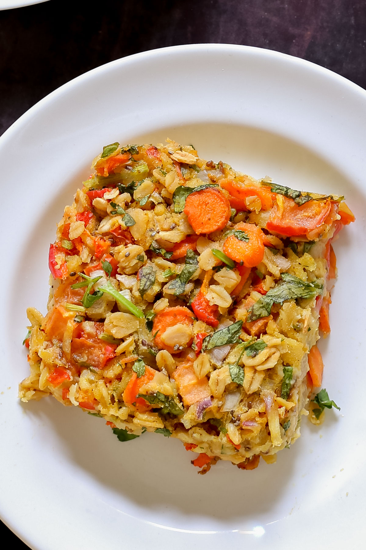 close-up of a piece of savory baked oatmeal on a white plate