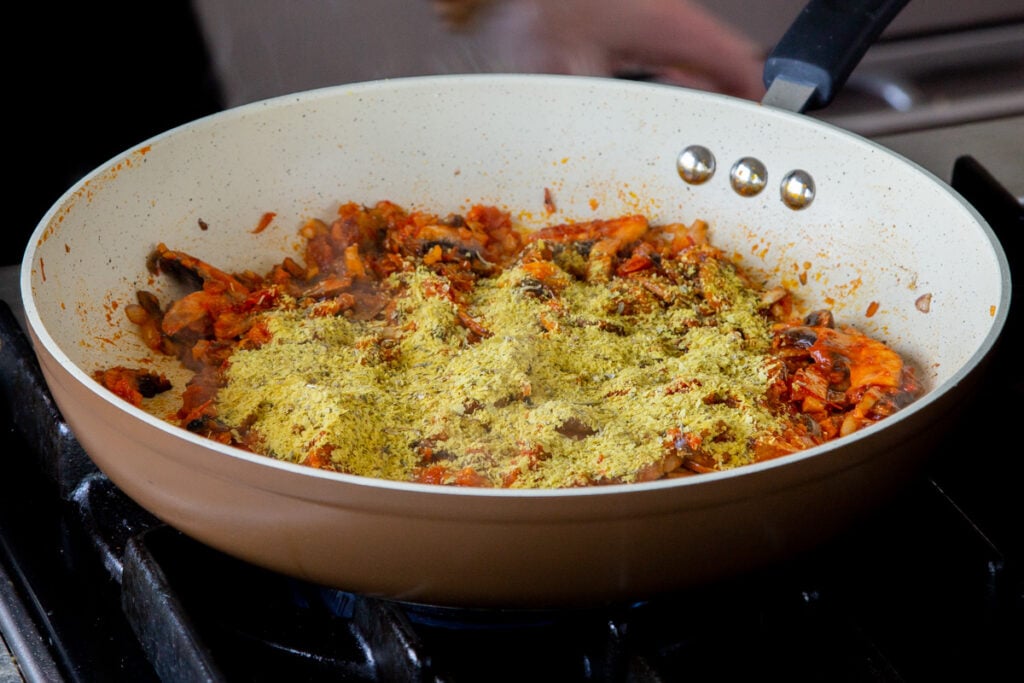 adding nutritional yeast to the pan