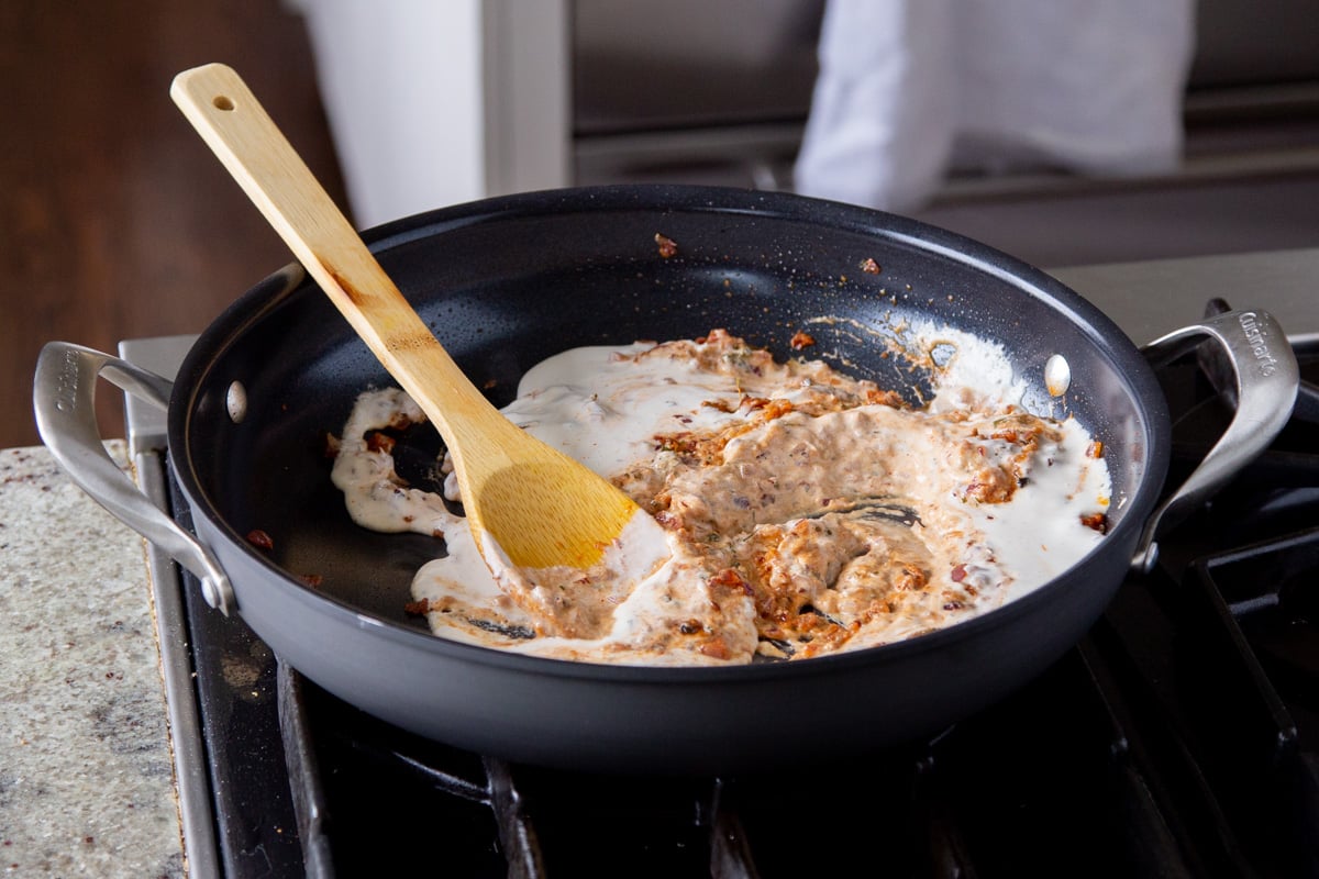adding vegan cream to the pan, before cooking