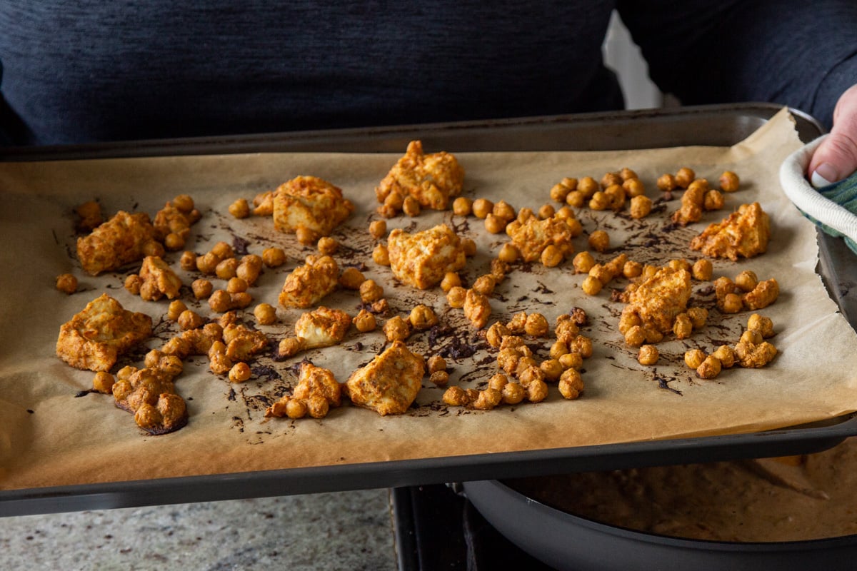 sauced chickpeas and tofu on the baking sheet after baking