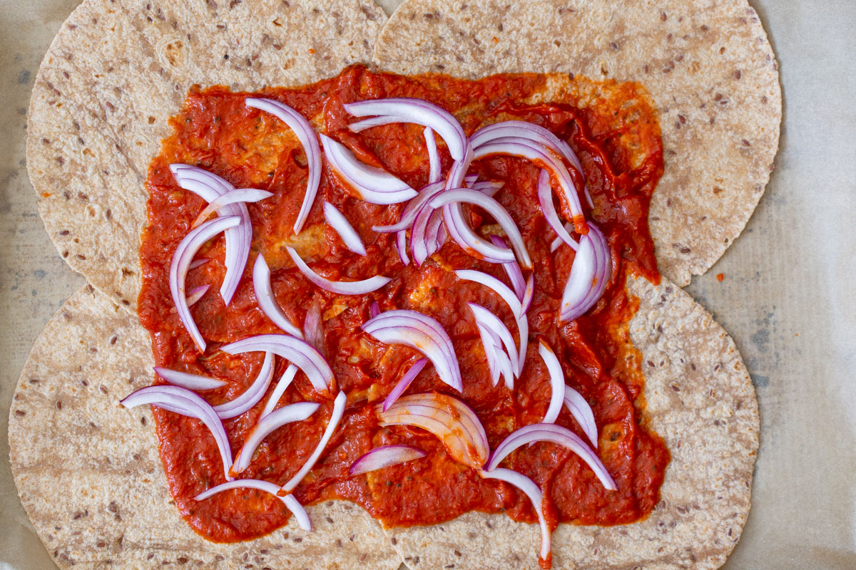 onions arranged on top of the pizza sauce