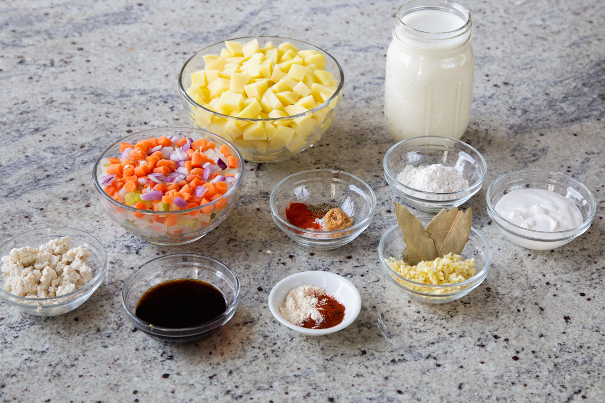 potatoes, veggies, and seasonings in containers on a kitchen countertop
