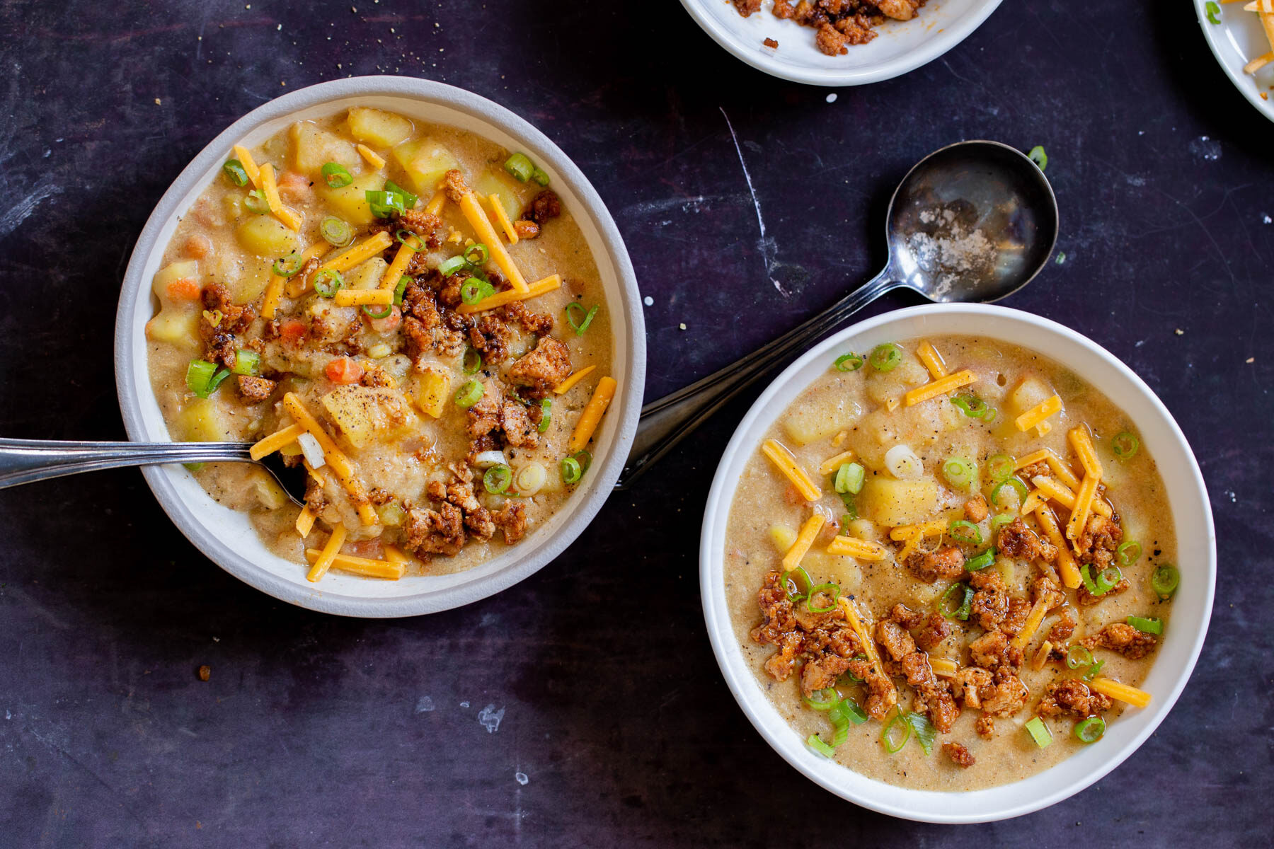 bowls of vegan potato soup after adding toppings