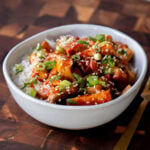 gochujang tofu stir fry in a bowl topped with sesame seeds and green onion