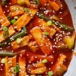 gochujang tofu stir fry in a pan topped with sesame seeds and green onion