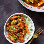 gochujang tofu stir fry in a bowl topped with sesame seeds and green onion