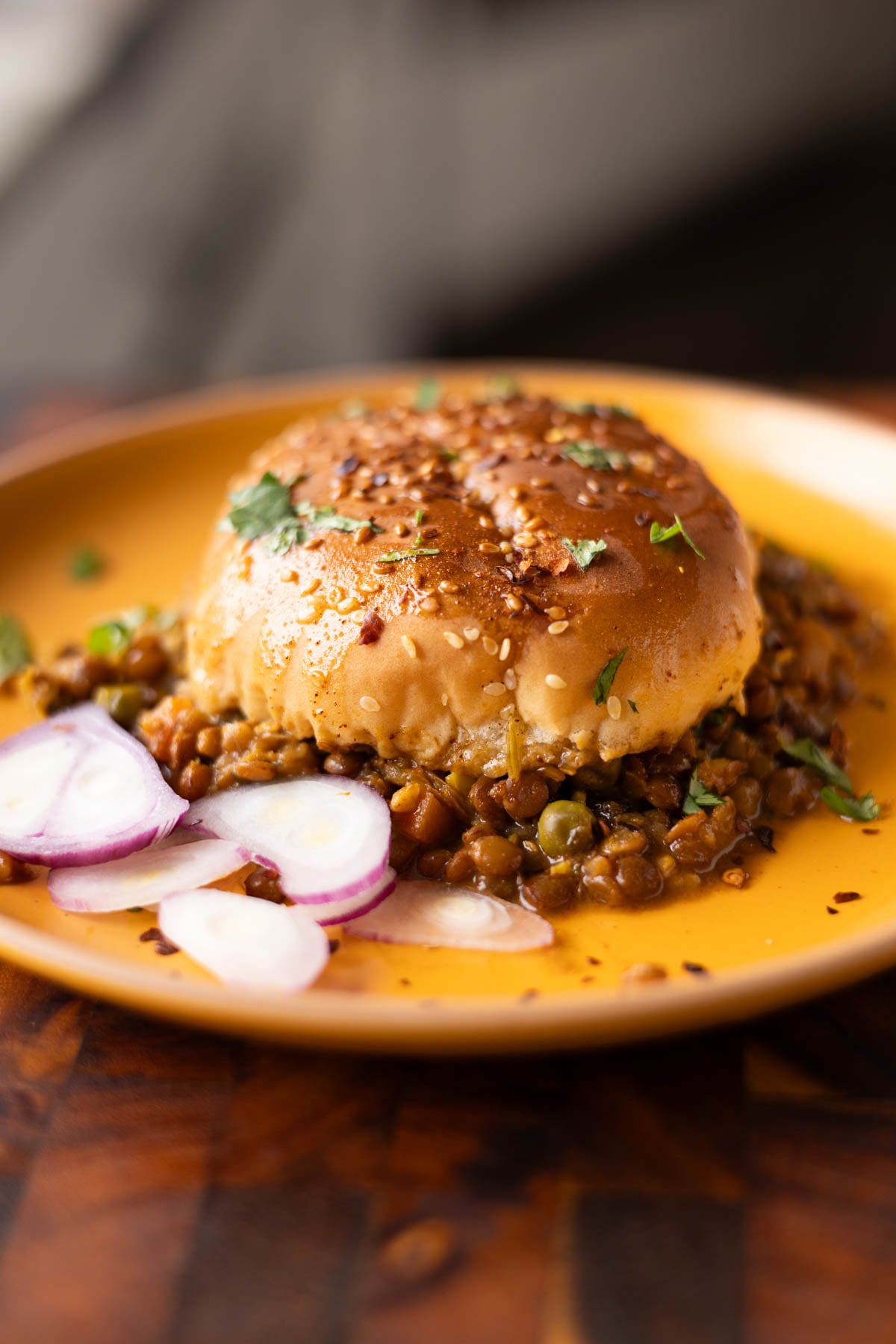 serving of keema lentil casserole on a plate with sliced onion