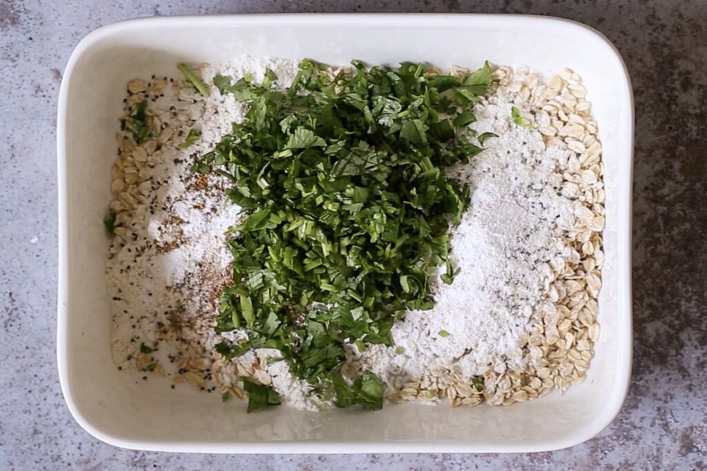 oats, flour, seeds, and cilantro in the baking pan before mixing
