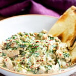 close-up of baked Indian spinach curry with soy curls in a bowl with naan
