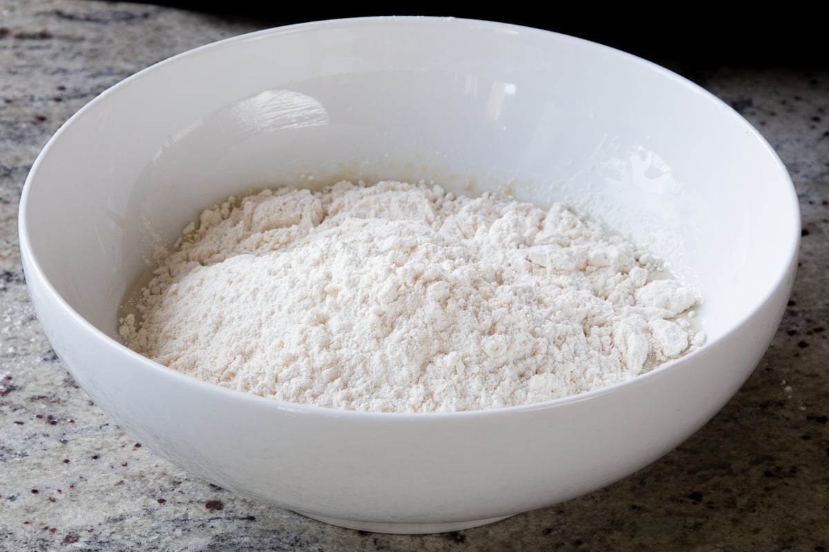 flour mixture added to the bowl of yeast