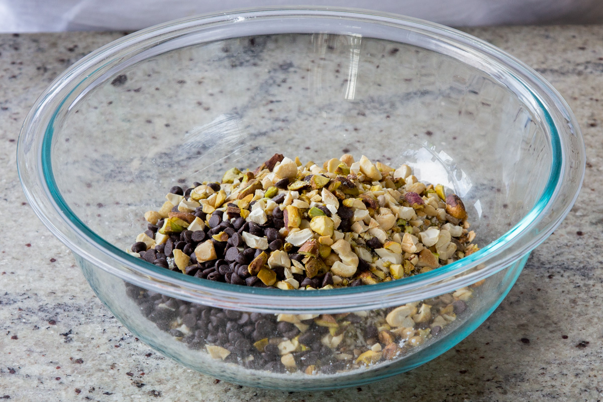 adding chocolate chips and chopped nuts tot he bowl