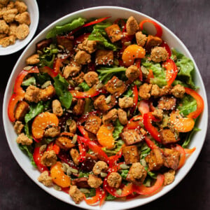 vegan summer salad in a bowl with tofu, croutons, veggies and oranges