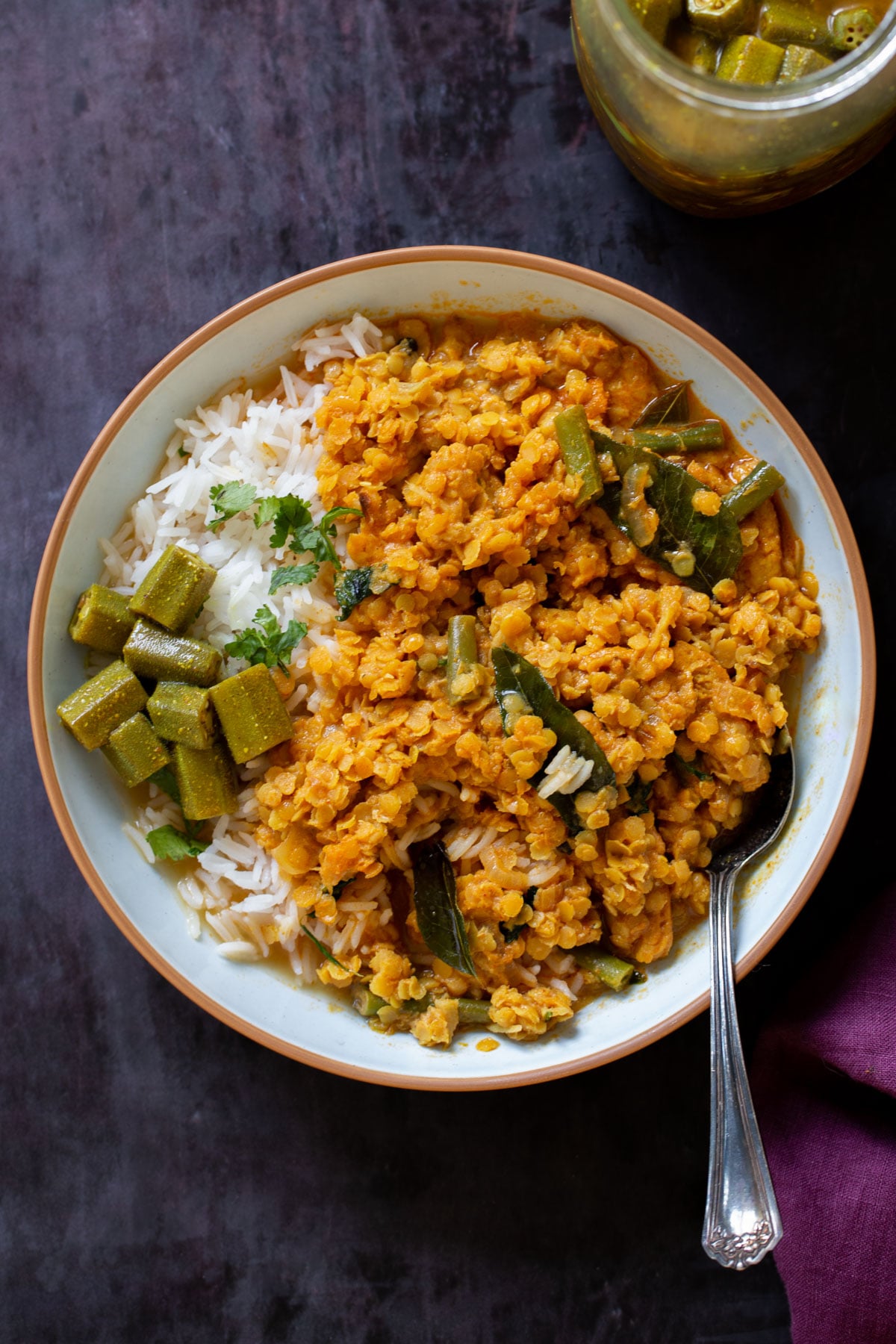 bowl of vegan dalcha with rice and veggies