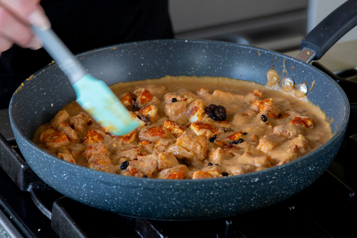 mixing crispy tofu "mutton" back into the pan of Pahadi curry sauce