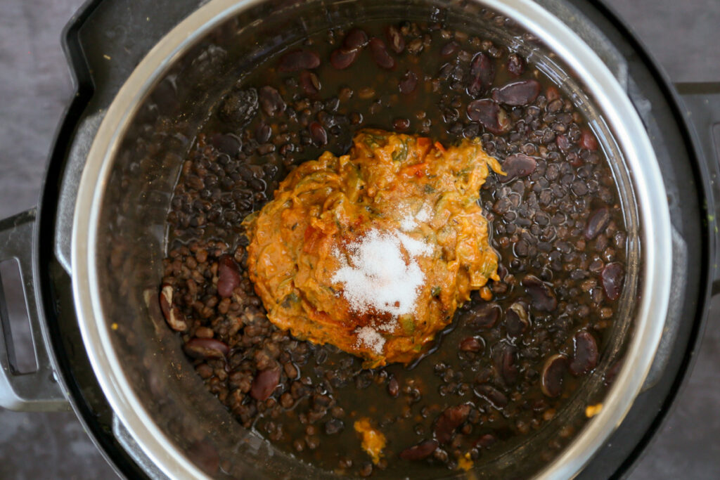 adding yogurt, sauce, and spices to the cooked dal