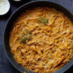 pumpkin alfredo pasta in the pan topped with the rosemary breadcrumbs