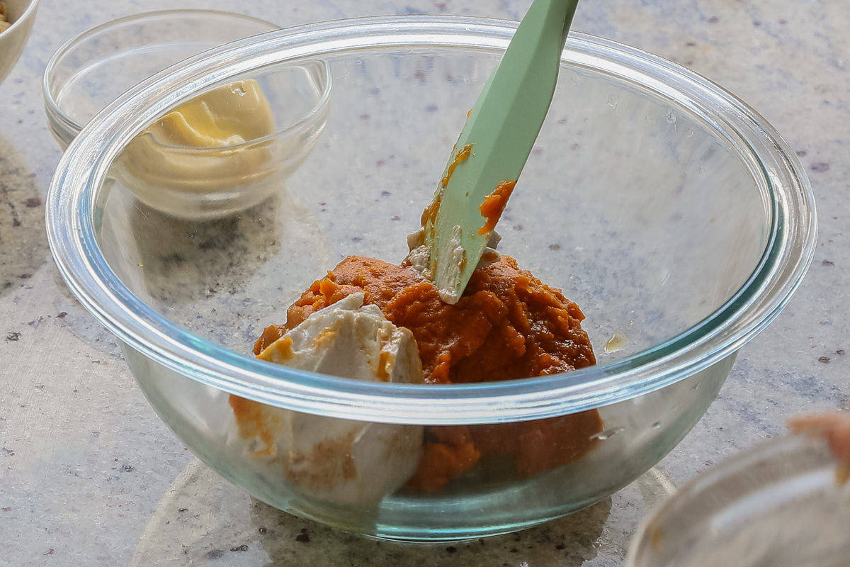 adding the pumpkin and coconut cream to a bowl