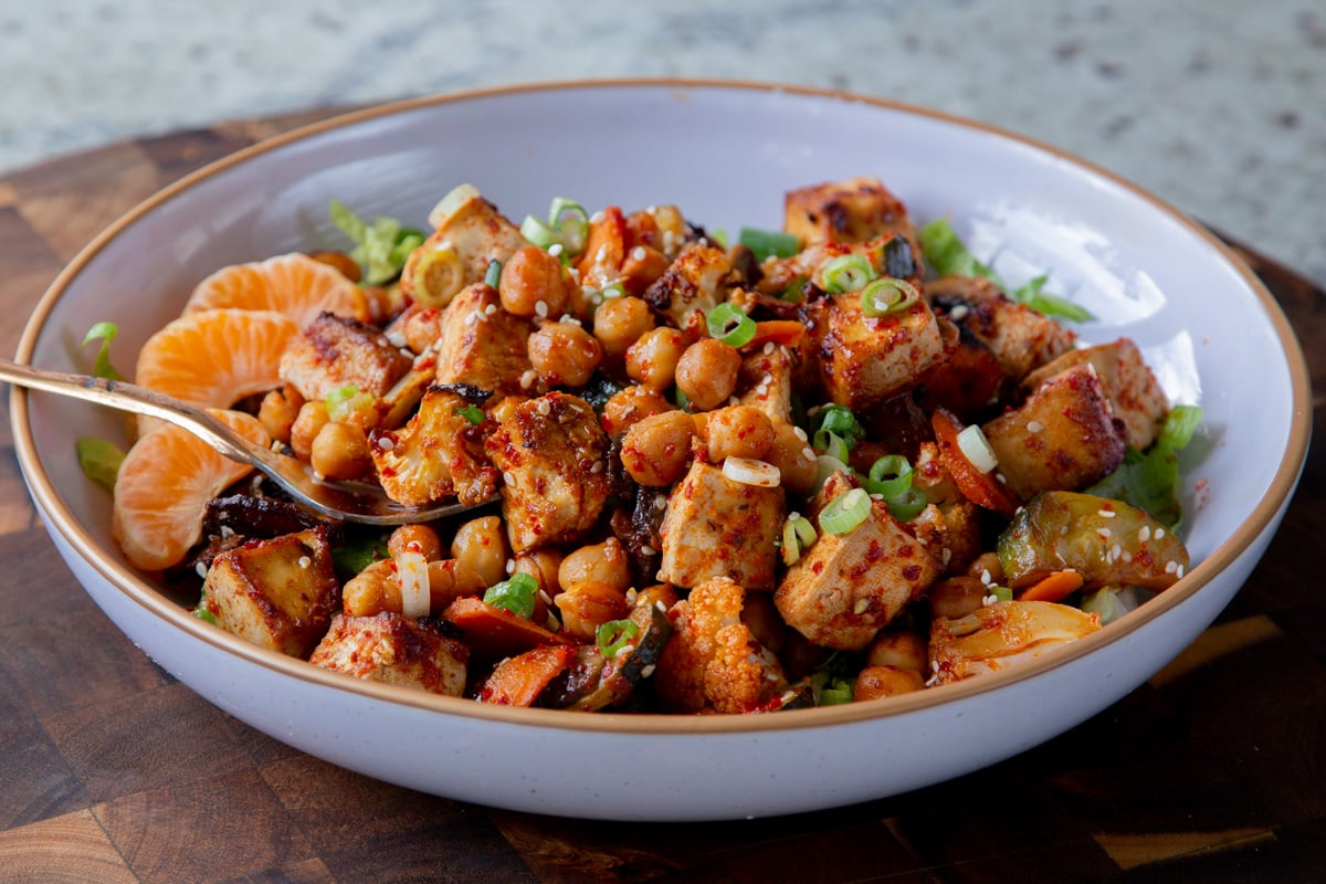 gochujang tofu and veggies in bowl over lettuce