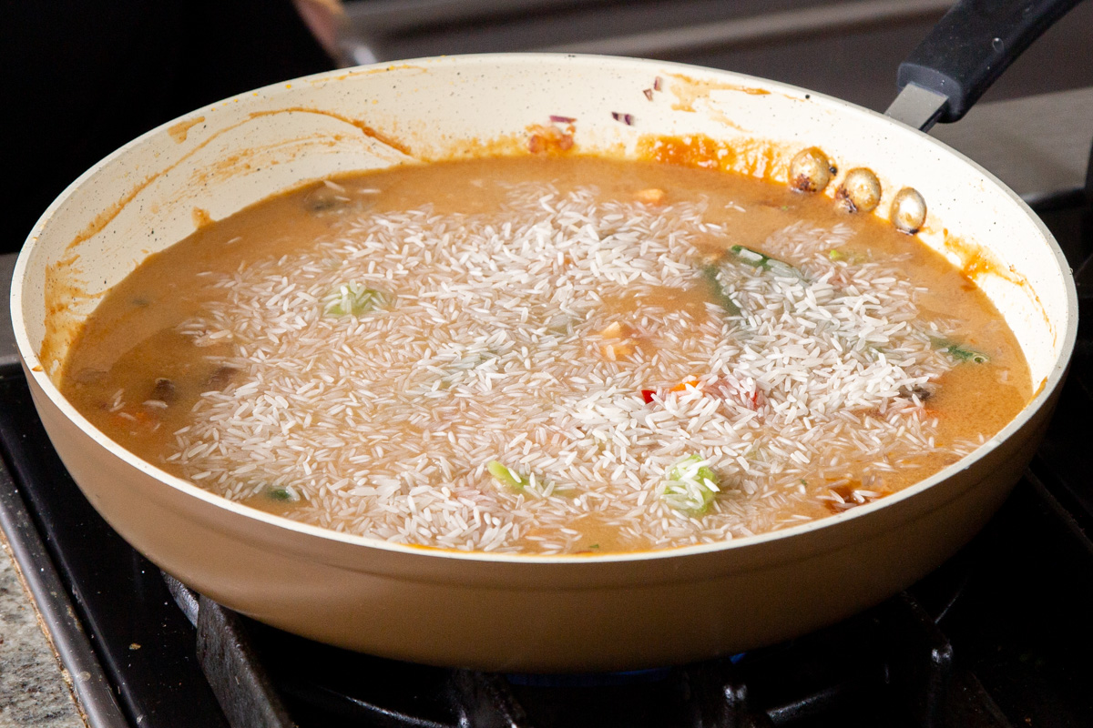adding rice to the pan