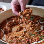 dipping sourdough into Dhaba chicken white beans