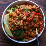 quinoa chickpea casserole in a bowl with lime wedge and green onion