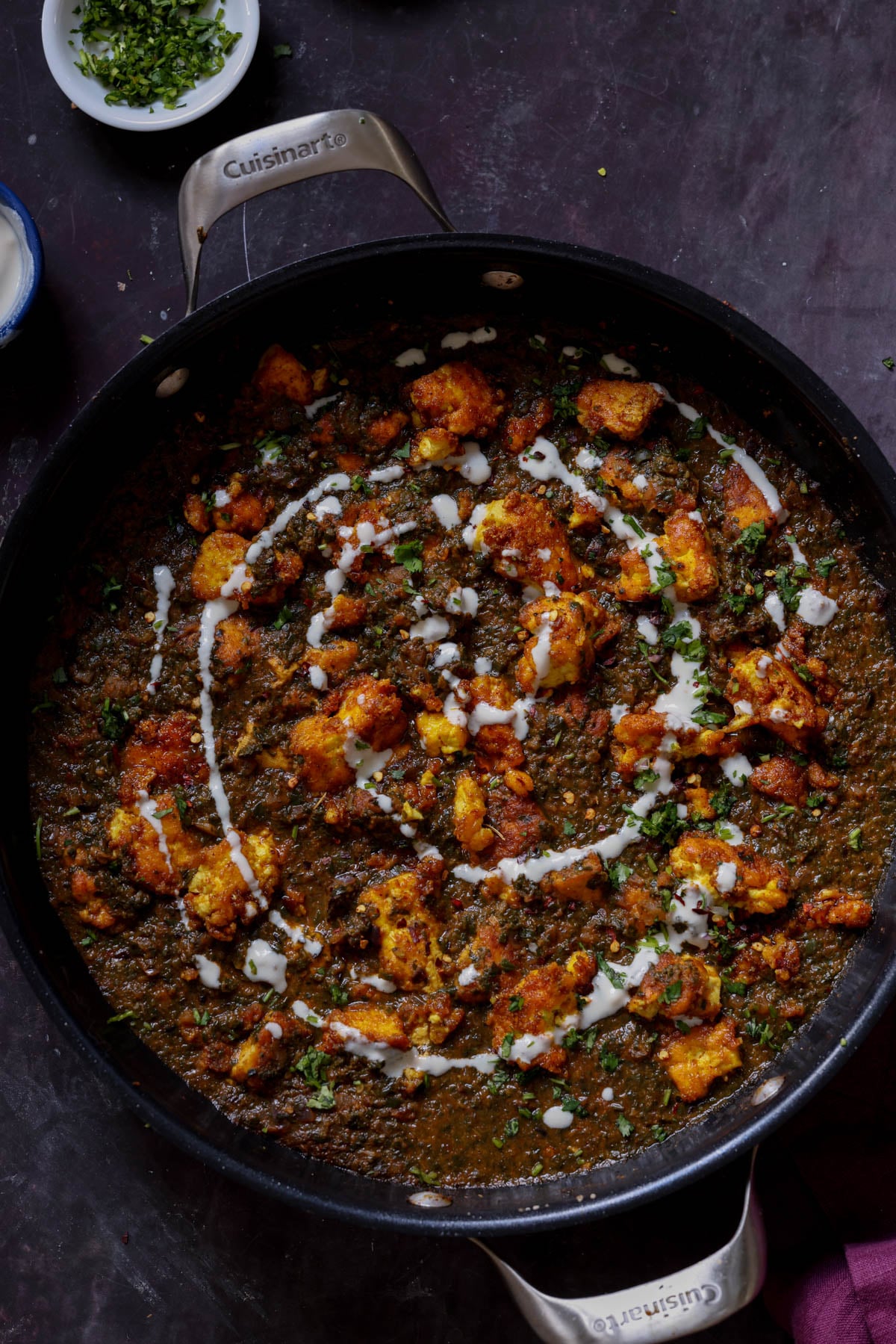 vegan chicken saagwala in the pan with all of the garnishes on top