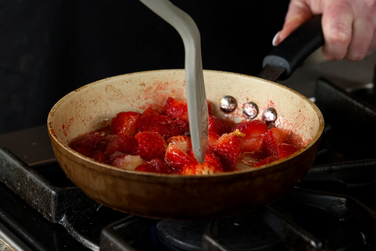mashing the berries with a spatula