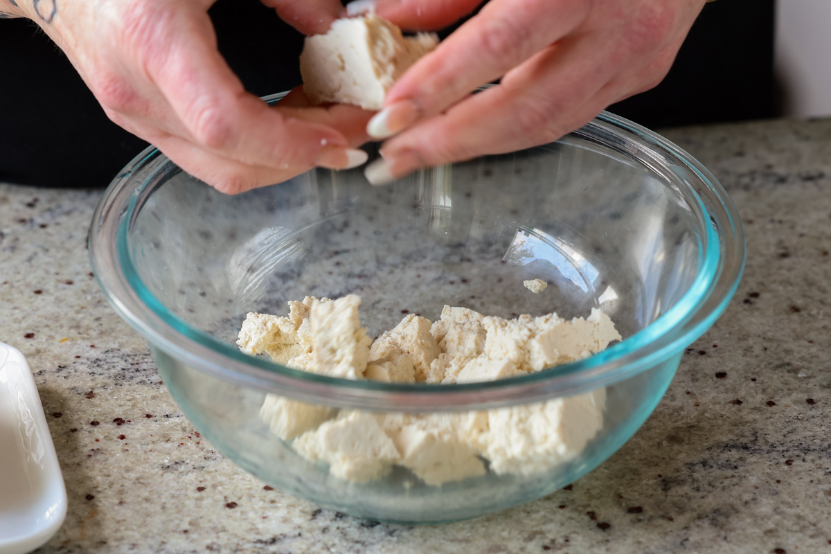 tearing up the tofu into pieces