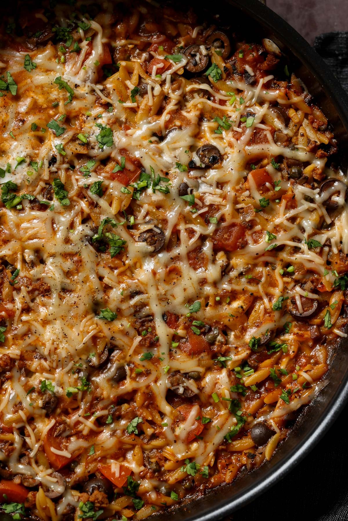 close-up of orzo puttanesca in the pan