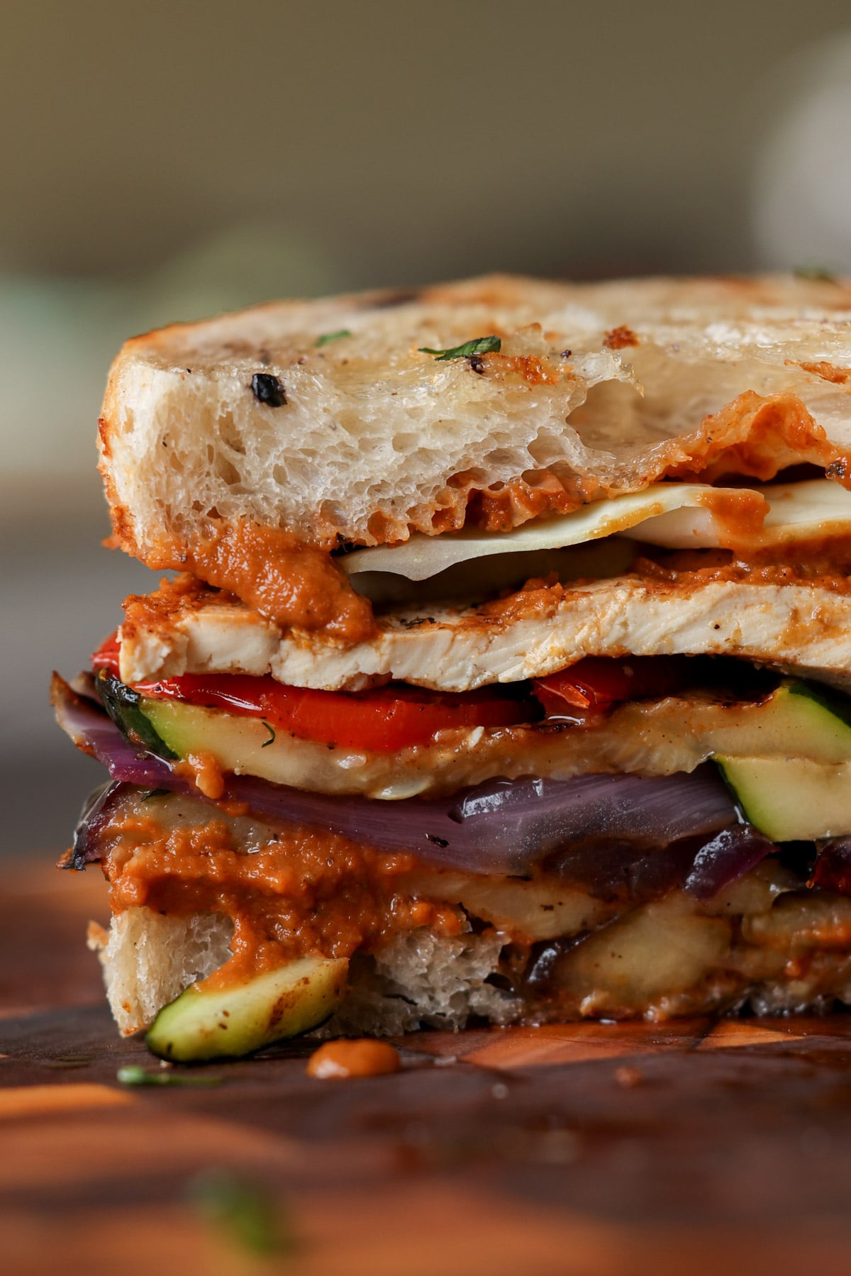 close-up of grilled veggie sandwich sliced in half on the cutting board