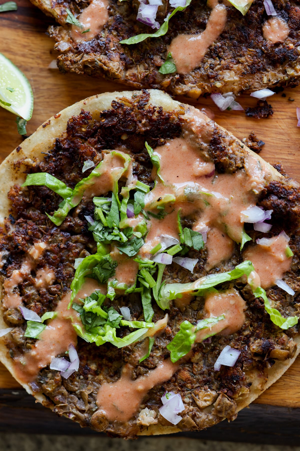 close-up of a vegan smash burger taco with butter chicken sauce