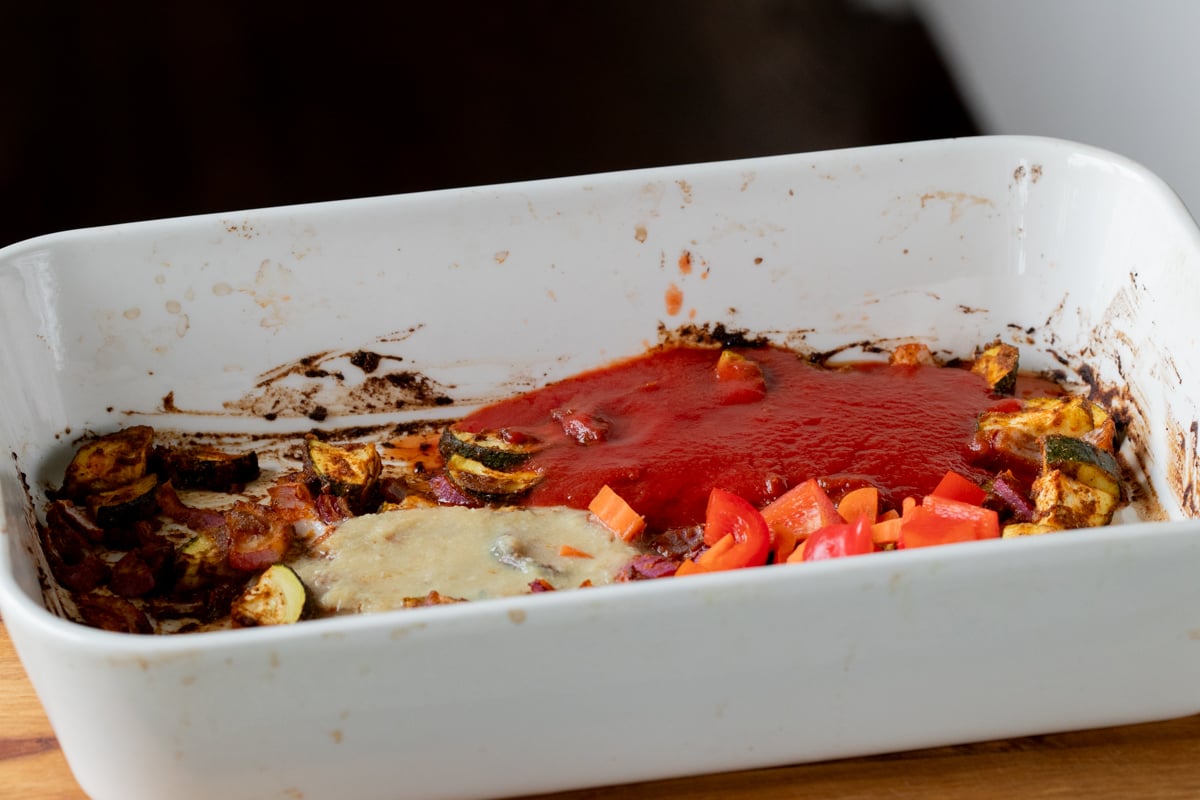 adding rest of the curry ingredients to the zucchini in the pan
