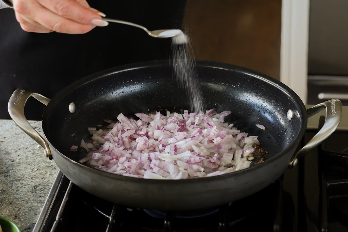 adding salt to the onion