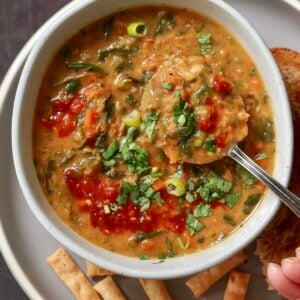spoon taking a bite of red lentil spinach soup