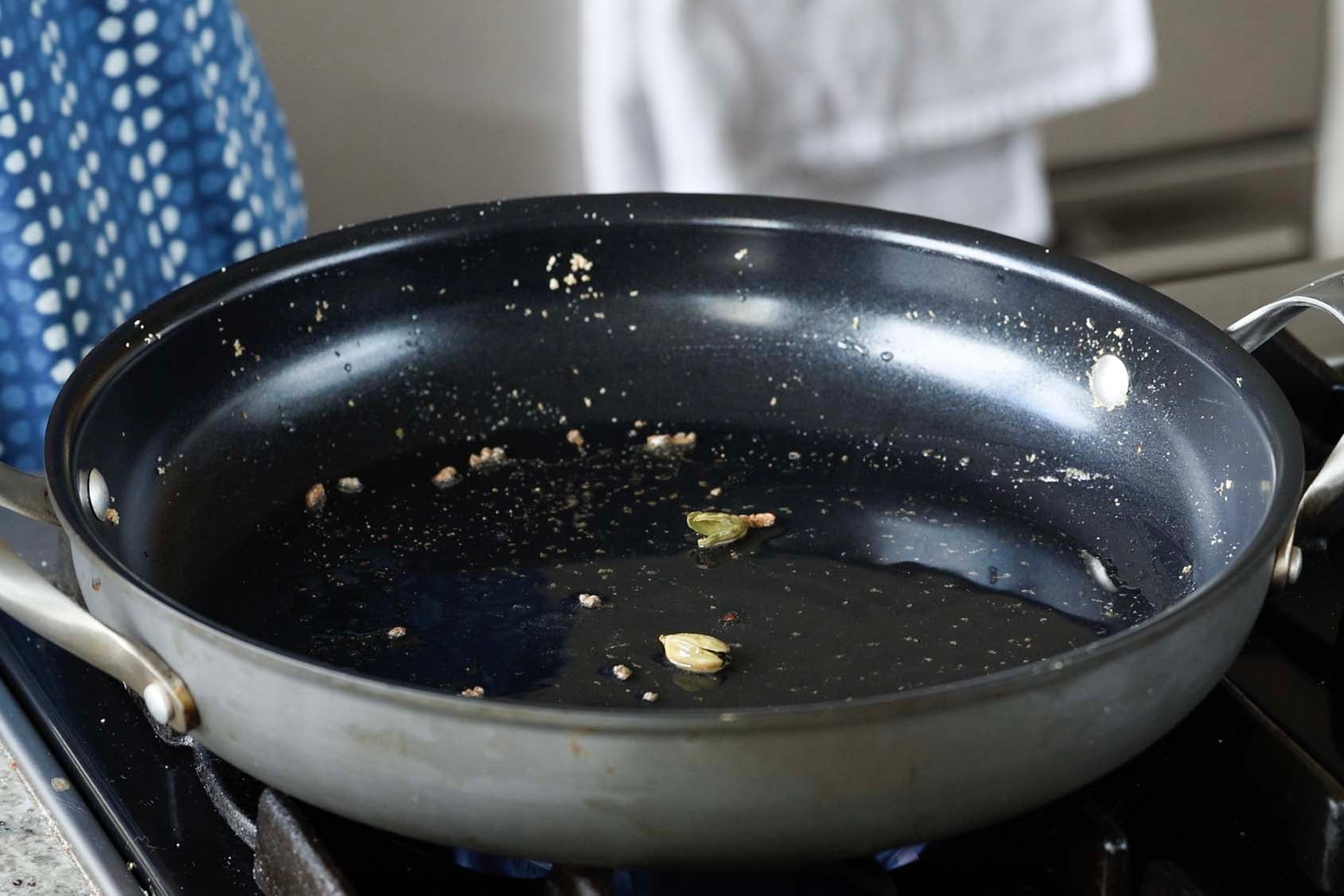 adding cardamom to the pan