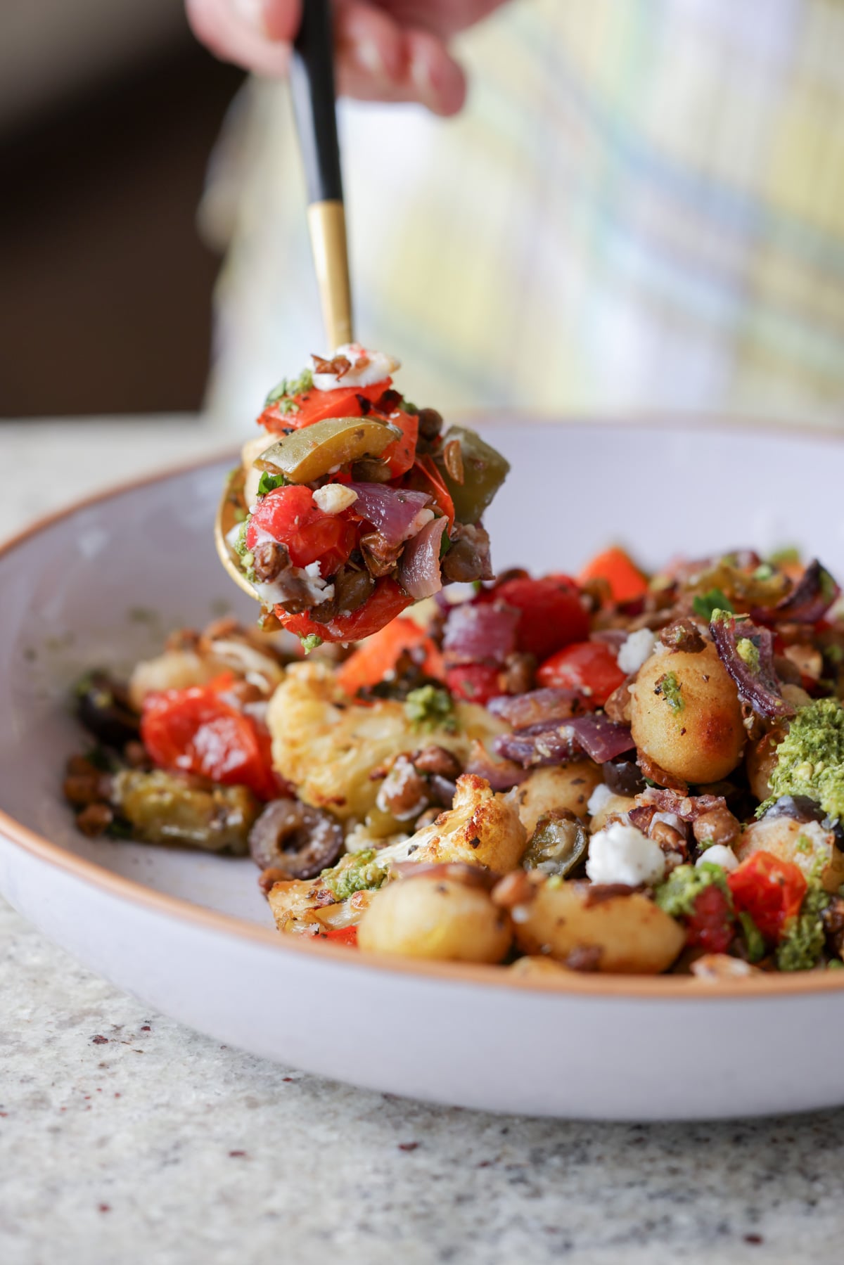 spooning a bite of sheet gnocchi and vegetables