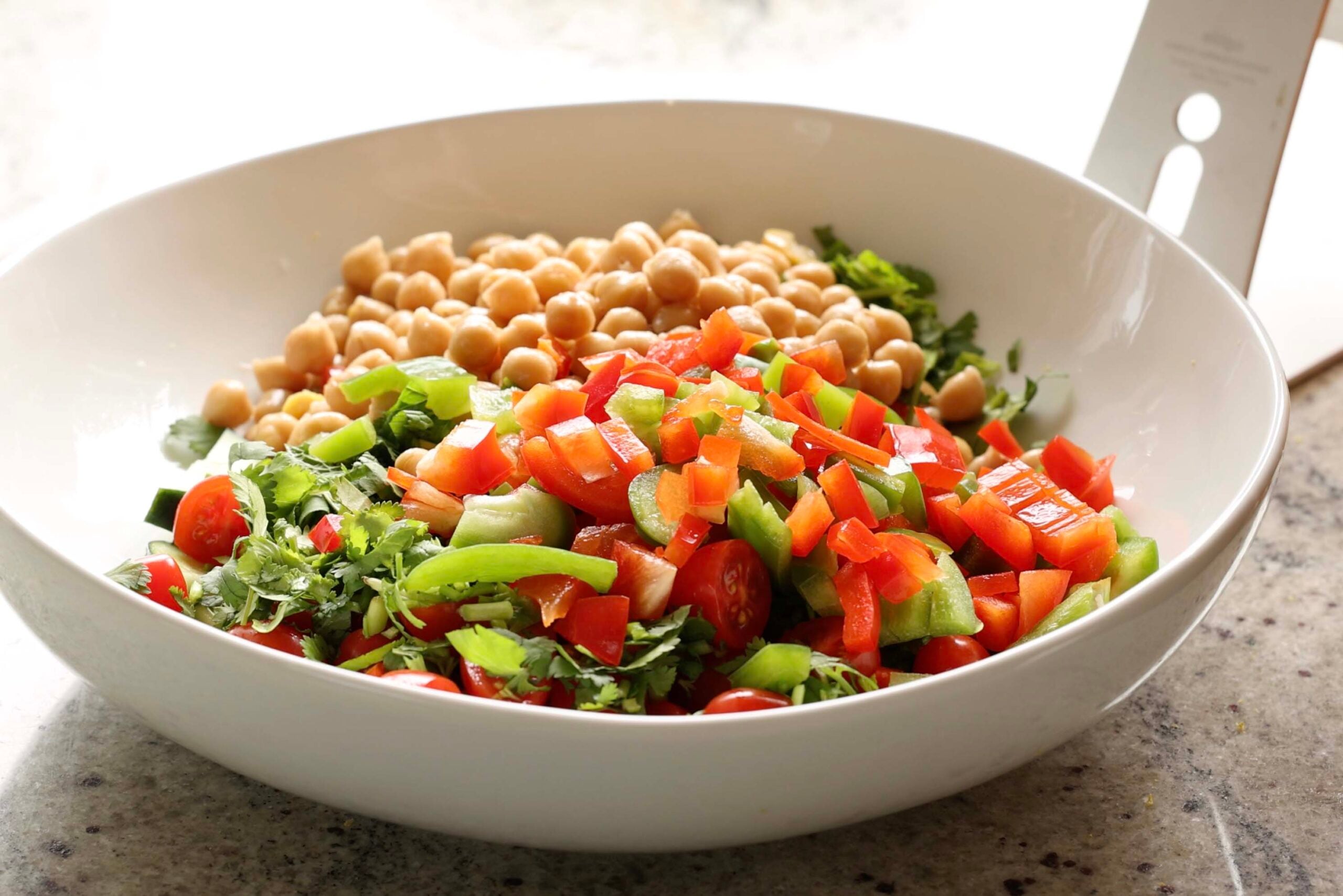 adding chickpeas to the bowl