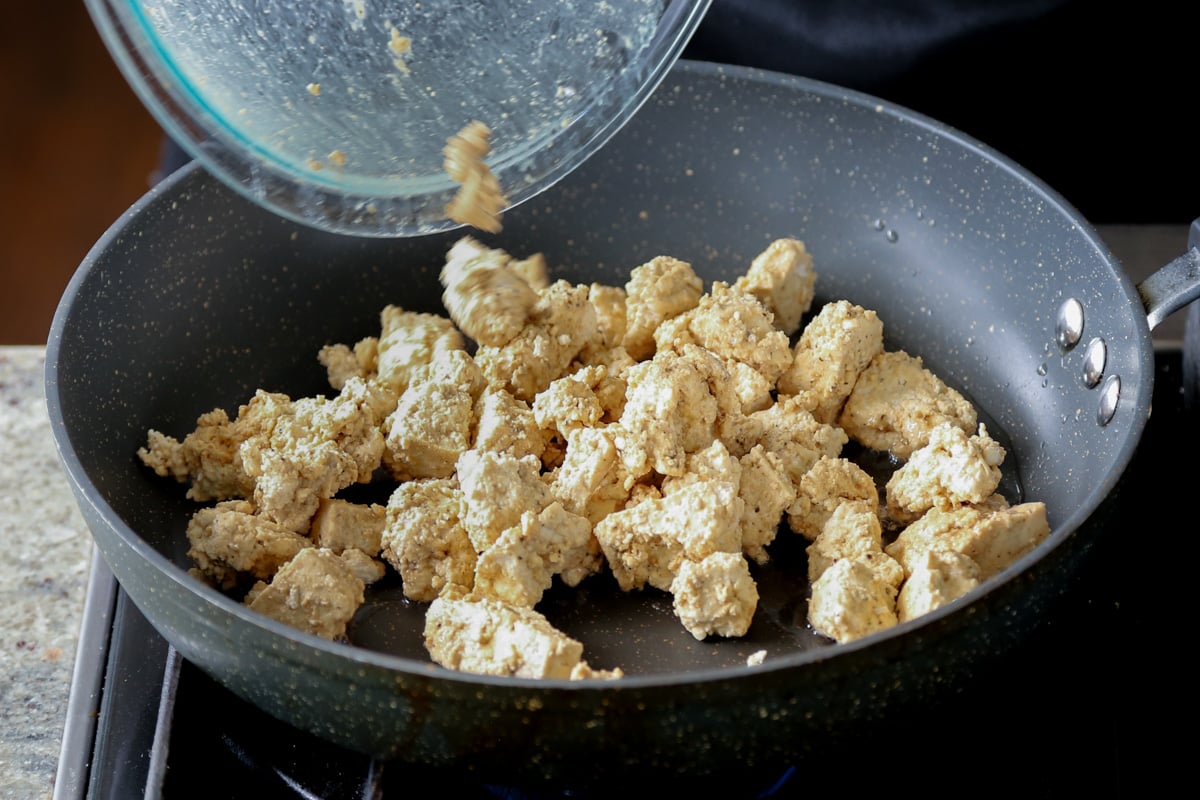 adding tofu to the pan