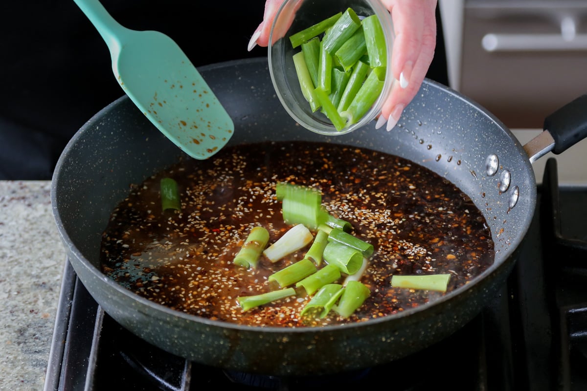 adding green onions to the pan
