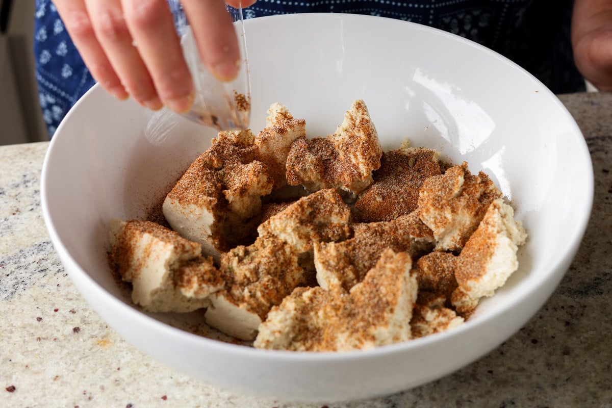 adding the spice rub to the tofu