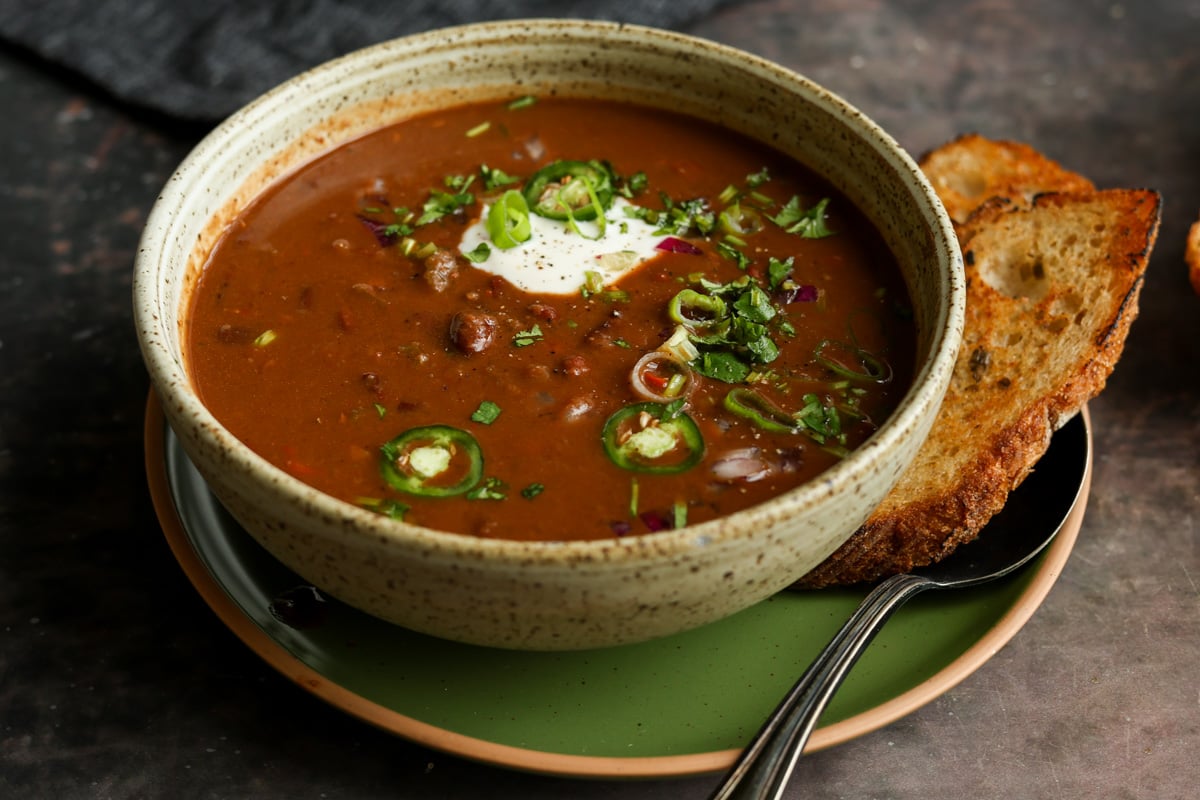 kidney bean chili in a bowls with vegan sour cream and other toppings
