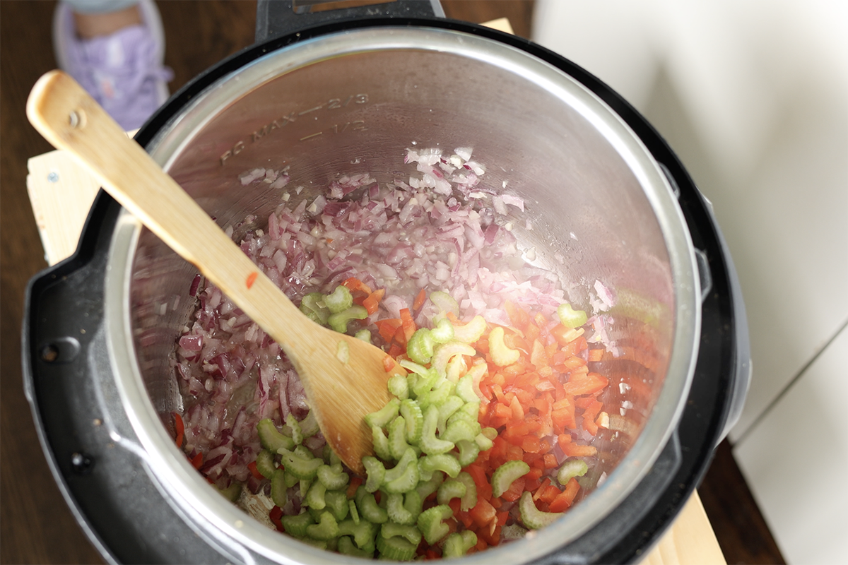 adding celery and bell pepper to cooked onions