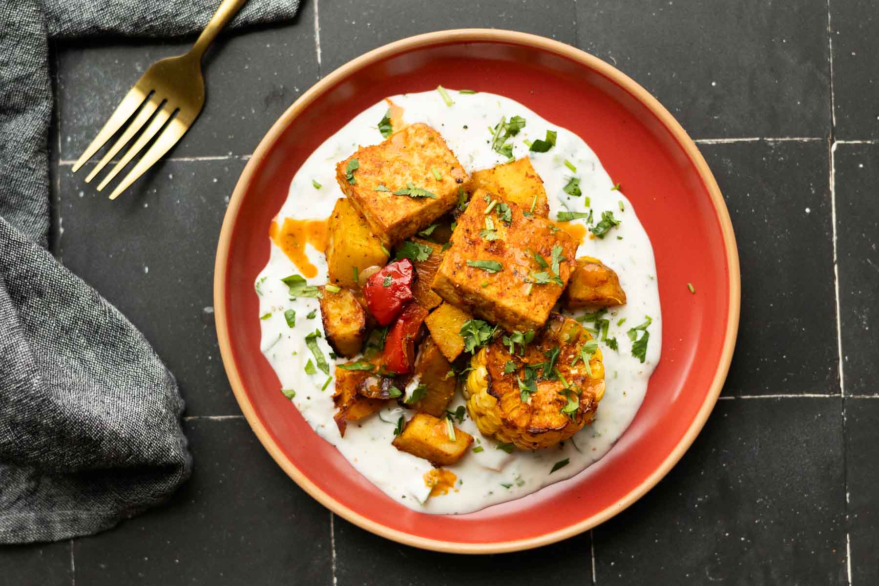 peri-peri tofu and vegetables on a bed of the yogurt sauce